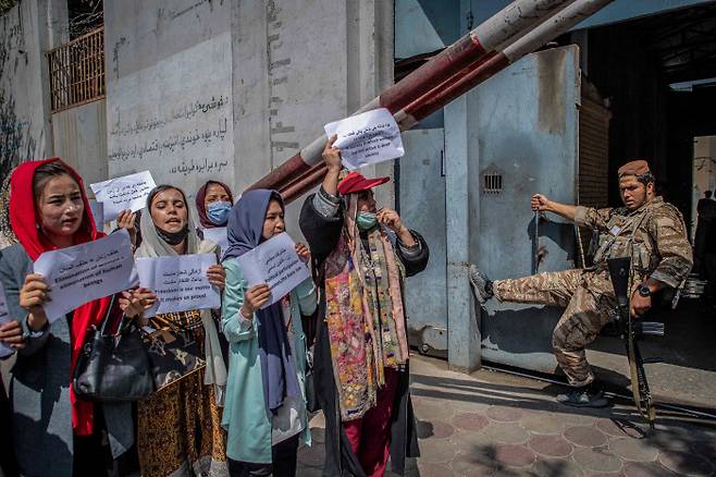 지난 9월 19일(현지시간) 아프가니스탄 수도 카불의 전 여성부 청사 앞에서 탈레반 대원이 지켜보는 가운데 여성 권리 증진을 요구하는 시위가 벌어지고 있다.  / 카불 AFP=연합뉴스