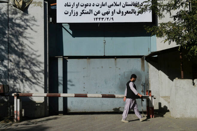 아프가니스탄 수도 카불에서 지난 9월 17일(현지시간) 한 남성이 탈레반에 의해 폐쇄된 전 정부의 여성부 건물 입구를 지나고 있다. 여성부 건물 현판 자리에는 ‘기도·훈도 및 권선징악부’ 간판이 걸려 있다. / 카불 AFP=연합뉴스
