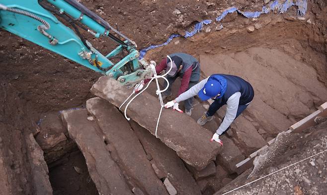 서울 종로구 누하동에서 진행된 발굴에서 조선시대 인경궁의 배수로로 보이는 유적이 발견돼 관계자들이 덮개돌을 정리하고 있다. 불교문화재연구소 제공