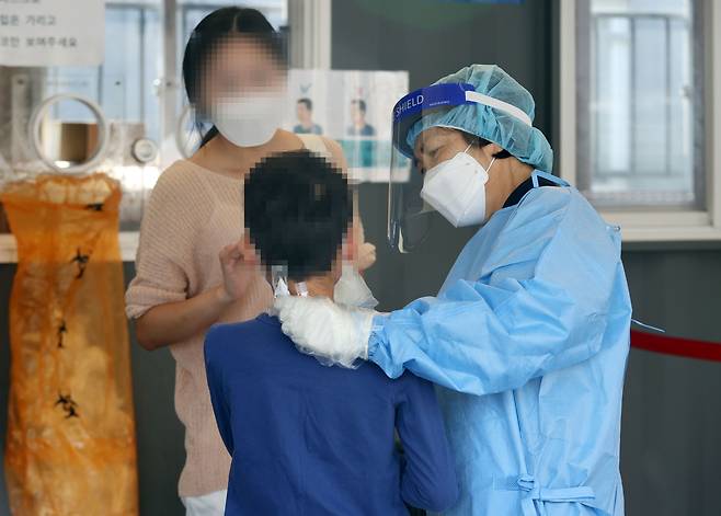 3일 서울역광장에 마련된 신종 코로나바이러스 감염증(코로나19) 임시 선별검사소에서 한 어린이가 검사를 받고 있다. 사진은 본 기사와 무관. [사진 출처 = 연합 뉴스]