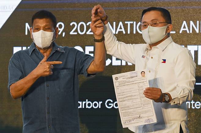 로드리고 두테르테 필리핀 대통령(왼쪽)이 지난 2일(현지시간) 수도 마닐라의 선거관리위원회에서 부통령 후보 등록을 마친 정치적 동반자이자 최측근인 크리스토퍼 봉 고 상원의원과 손을 맞잡고 있다. 마닐라=AP연합