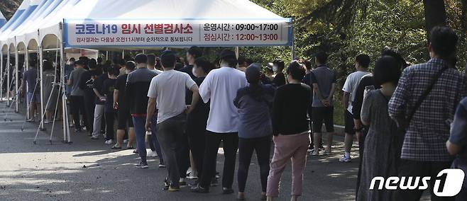 추석 연휴 마지막날인 22일 오전 울산 남구 문수축구경기장에 마련된 임시 선별검사소를 찾은 시민들이 신종 코로나바이러스 감염증(코로나19) 검사를 받기 위해 줄을 서 대기하고 있다. 2021.9.22/뉴스1 © News1 윤일지 기자