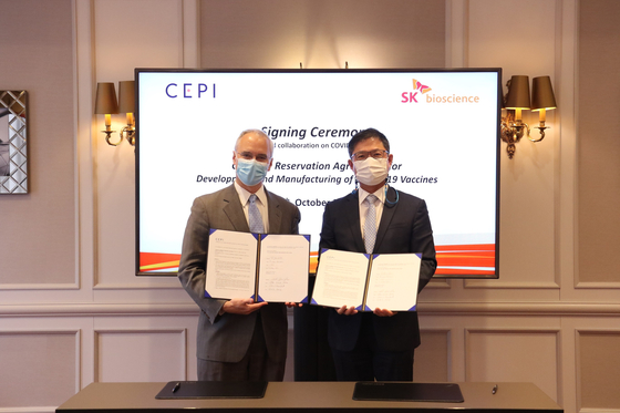 Ahn Jae-yong, CEO of SK Bioscience, right, and Richard Hatchett, CEO of the Coalition for Epidemic Preparedness Innovations, pose for a photo after signing an agreement to extend the capacity reservation contract for another year on Oct. 5. [SK BIOSCIENCE]