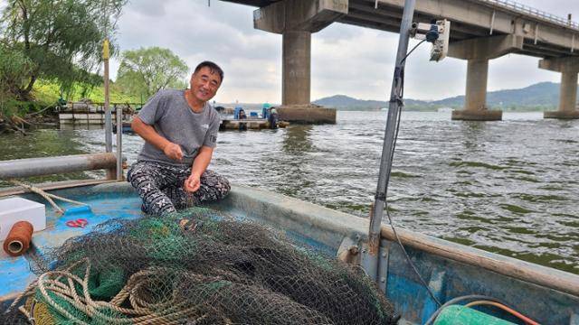 박찬수 고양 행주어촌계 어부가 5일 한강하구에서 자신의 어선에 올라 그물을 수리하고 있다. 이종구 기자