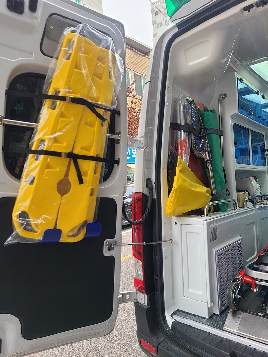 `음압구급차` 뒷문 왼쪽에 노란색으로 된 `분리형 들것`이 고정돼 있다. <신수현 기자>