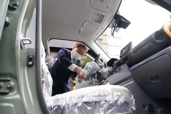 문재인 대통령이 6일 오후 청와대에서 광주형 일자리 사업으로 생산된 현대차의 첫 경형SUV(스포츠유틸리티차) '캐스퍼'를 인도받아 탑승하기 앞서 비닐을 제거하고 있다. '광주형 일자리'는 지역의 노·사·민·정이 지역 주도의 맞춤형 발전과 노사 간 동반 성장을 이루기 위한 경제 모델이다. 청와대 제공