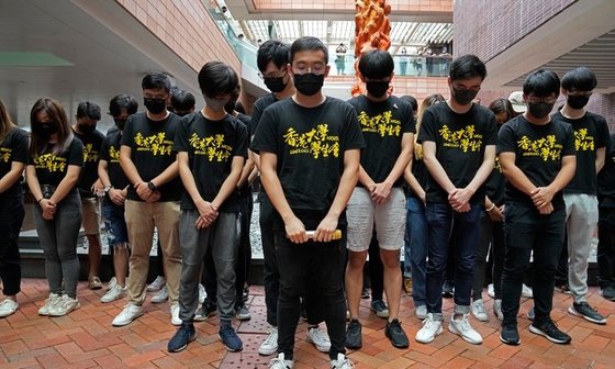 홍콩대학에서 학생들이 지난 6월 중국 톈안먼 민주화 시위 희생자들을 추모하는 '수치의 기둥'(Pillar of Shame) 조각상 앞에 모여 희생자들을 위해 묵념하고 있다. [AP=뉴시스]