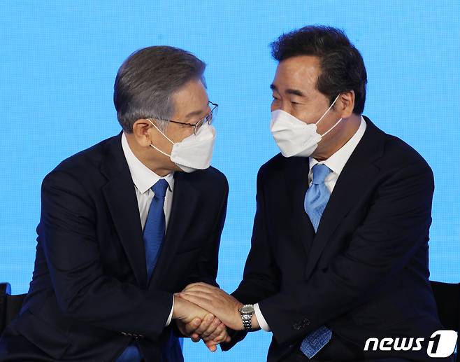 더불어민주당 제20대 대통령선거 후보에 선출된 이재명 경기지사가 10일 오후 서울 송파구 올림픽공원 SK올림픽핸드볼경기장에서 열린 서울 지역 경선 및 3차 국민선거인단 투표에서 최종 후보 선출 발표를 들을 후 이낙연 전 대표에게 축하를 받고 있다. 이 후보는 서울 지역 경선에서 51.45%를 얻어 누적 득표율 50.29%를 기록, 결선 투표 없이 더불어민주당 20대 대통령 선거 후보에 선출됐다. 2021.10.10/뉴스1 © News1 국회사진취재단