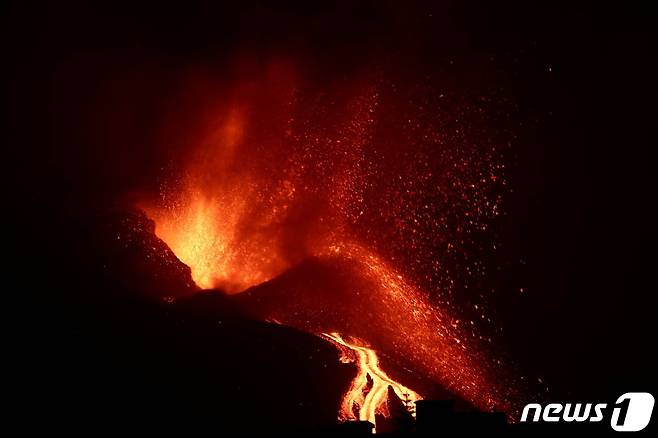 11일(현지시간) 스페인 카나리아 제도 라팔마섬의 쿰브레 비에호 화산에서 용암이 흘러내리고 연기가 치솟고 있다. 쿰브레 비에호 화산은 지난달 19일 처음 폭발한 뒤 계속 분화하고 있다. © 로이터=뉴스1 © News1 신윤하 기자