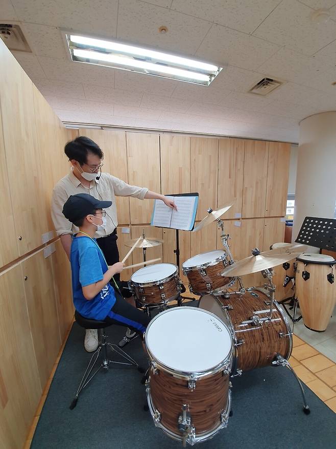 하늘초등학교 학생이 ‘더 빅밴드 라온’ 뮤지션에게서 드럼을 배우고 있다.