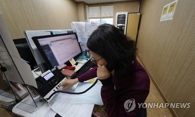 팔목 보호대 차고 백신 상담 (광주=연합뉴스) 박철홍 기자 = 12일 오후 광주 북구보건소 코로나19 콜센터에서 직원이 기존 코로나19 백신 예약과 부스터 샷과 독감 백신 접종 문의에 대응하느라 분주한 모습이다. 2021.10.12 pch80@yna.co.kr