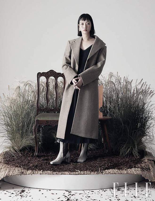 오트밀 컬러 롱 코트는 Low Classic. 블랙 슬립 드레스는 Leuni. 골드 빅 이어링은 1064 Studio. 스퀘어 토 화이트 앵클부츠는 Rekken.