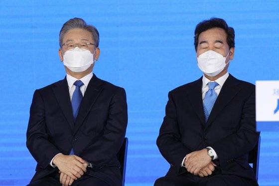 지난 10일 서울 송파구 올림픽공원에서 열린 민주당 서울 경선에서 결과 발표 직전 이재명 후보(왼쪽)와 이낙연 전 대표가 긴장한 채 귀를 기울이고 있다. 임현동 기자