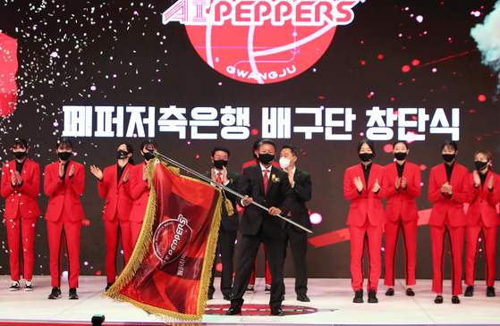 Matthew Chang, the CEO of Pepper Savings Bank AI Peppers Volleyball Team, flies the flag at the inauguration ceremony on Sept. 30. [YONHAP]