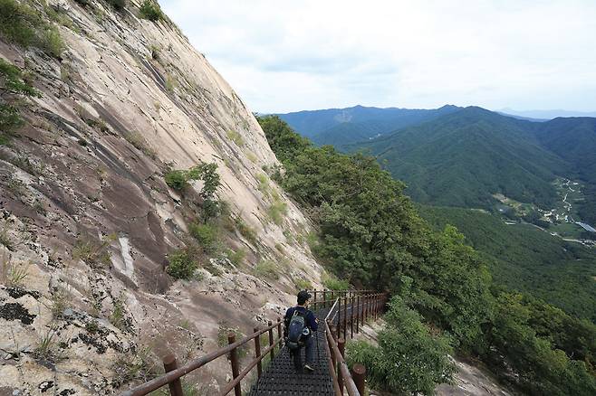 거대한 바위지대에 계단과 난간이 설치된 천주산 하산길.