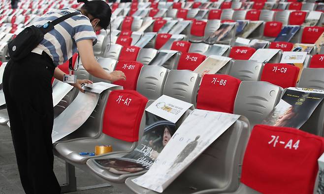 제26회 부산국제영화제 폐막식이 열리는 15일 부산 해운대구 영화의전당에서 관계자와 자원봉사자 등이 거리두기용 객석 포스터를 붙이고 있다. 연합뉴스