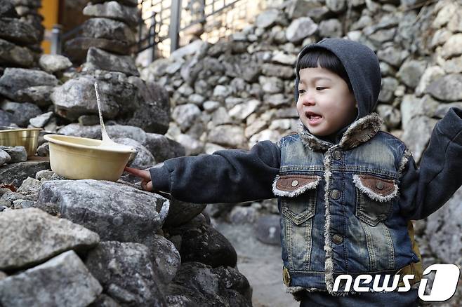 7일 전북 진안군의 아침 기온이 연일 영하 10도 이하를 기록하면서 마이산 탑사에 놓인 정화수에 하늘을 향해 역고드름이 솟아 올랐다. 이번에 생긴 역고드름의 길이는 10~16cm 크기로 3개가 만들어졌다. 한 어린이가 역고드름을 신기하게 바라보고 있다.(진안군제공)2019.1.7/뉴스1 © News1 김동규 기자