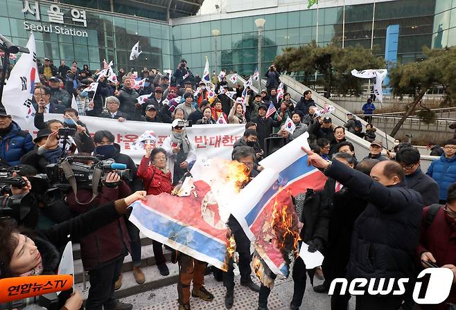 조원진 당시 대한애국당 대표와 보수단체 회원들이 2018년 1월22일 오전 서울역 광장에서 긴급기자회견을 열고 평창동계올림픽 남북 단일팀 합의에 반대하며 인공기를 불에 태우고 있는 모습(자료사진). 2018.1.22/뉴스1 © News1 구윤성 기자