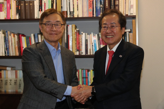 국민의힘 홍준표 대선 경선 후보가 16일 밤 국민의힘 대선후보 경선에서 탈락한 최재형 전 감사원장의 서울 양천구 목동 자택을 방문, 최 전 감사원장과 악수하고 있다.  연합뉴스