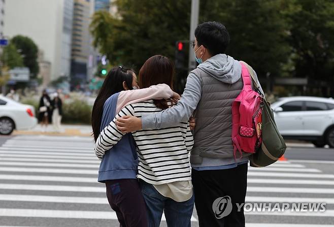 함께라면 추위쯤이야 (서울=연합뉴스) 서명곤 기자 = 전국 곳곳에 한파특보가 발령된 16일 오후 서울 시내 거리에서 한 가족이 서로를 안아주고 있다.이번 한파특보는 이날 오후 9시를 기해 발효된다. 서울에 10월 중 한파특보가 내려지는 것은 2004년 이후 17년만이다.  2021.10.16 seephoto@yna.co.kr