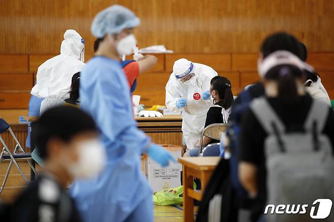 광주 북구보건소 의료진들이 북구 한 초등학교에 설치된 이동선별진료소에서 학생들을 대상으로 신종 코로나바이러스 감염증(코로나19) 전수조사를 실시하고 있다.(광주북구 제공)2021.7.21/뉴스1