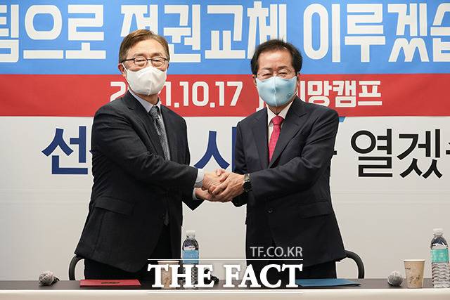 홍준표 국민의힘 대선 예비후보(오른쪽)와 최재형 전 감사원장이 17일 오전 서울 여의도 jp희망캠프에서 열린 영입행사에서 손을 맞잡고 기념촬영을 하고 있다. /홍준표 캠프 제공