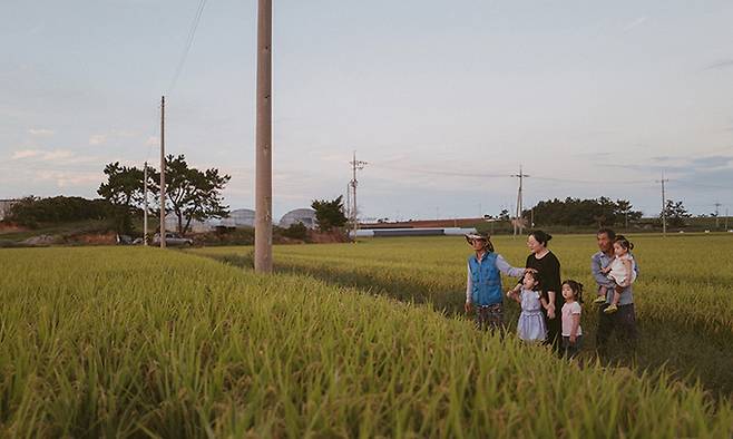 농민 이덕한(69)씨가 귀농한 아들네 가족과 함께 논두렁에 서서 노을을 바라보고 있다.