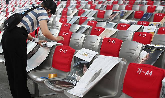 지난 15일 부산 해운대구 영화의전당에서 관계자와 자원봉사자 등이 거리두기용 객석 포스터를 붙이고 있다. 연합뉴스