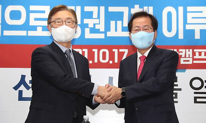 국민의힘 홍준표 대선 경선 후보(오른쪽)와 경선 예비후보였던 최재형 전 감사원장이 17일 서울 여의도 홍 후보 캠프 사무실에서 열린 ' 최재형 전 감사원장 영입 기자회견' 에서 손을 잡고 인사하고 있다. 연합뉴스