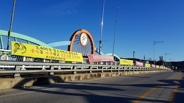 경북 울진 근남면에 추진되는 스마트축산 ICT시범단지 조성 사업과 관련, 반대하는 지역 주민들의 현수막과 단지에 입주하는 축산 농가들의 지지 현수막이 18일 근남면 수산교 양쪽에 걸려 있다.