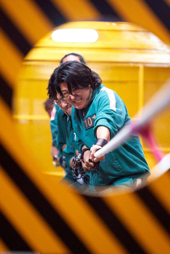 A scene from "Squid Game" in which Deok-soo is playing tug-of-war with his teammates to get to the next stage of the survival game. [NETFLIX]