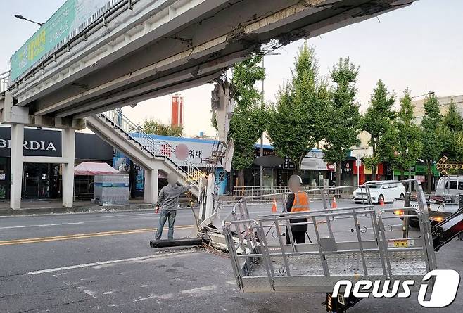 지난 18일 오전 4시30분쯤 광주 북구 북동 수창초등학교 인근 도로를 주행 중이던 4.5톤 고물상 트럭이 육교를 들이받는 사고가 발생, 관할 지자체 관계자들이 복구 작업을 하고 있다.(광부 북부소방서 제공)2021.10.18/뉴스1 © News1 정다움 기자