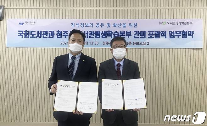 현진권 국회도서관장(왼쪽)과 풍경섭 충북 청주시 도서관평생학습본부장이 19일 업무협약을 체결하고 있다.(청주시 제공).2021.10.19/© 뉴스1