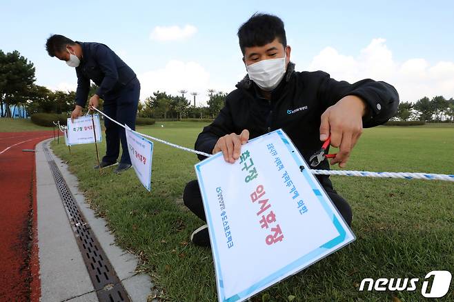 인천환경공단이 19일 코로나19로 폐쇄한 테니스장, 축구장 등 체육시설을 전면 개방한다. 인천환경공단 관계자가 축구장 임시 휴장 알림판을 제거 하고 있다. 2021.10.19/뉴스1 © News1 정진욱 기자