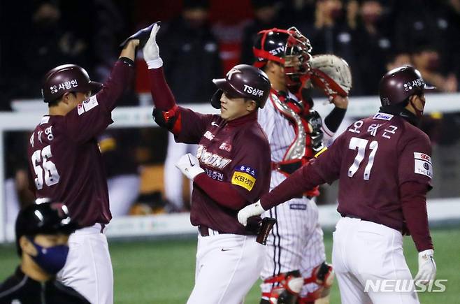 [서울=뉴시스] 배훈식 기자 = 수도권 야구장 관중 입장이 재개된 19일 오후 서울 송파구 잠실야구장에서 열린 2021 KBO리그 LG 트윈스와 키움 히어로즈와의 경기, 5회초 1사 1, 2루 상황에서 키운 대타 김웅빈이 3점 홈런을 친 뒤 홈을 밟으며 하이파이브를 하고 있다. 2021.10.19. dahora83@newsis.com