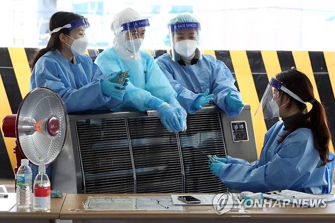 성미 급한 한파에 난로 가동한 선별진료소 (광주=연합뉴스) 정회성 기자 = 갑작스러운 한파가 이어진 18일 오전 광주 북구 선별진료소에서 의료진이 온열기기로 추위를 견디고 있다. 2021.10.18 hs@yna.co.kr