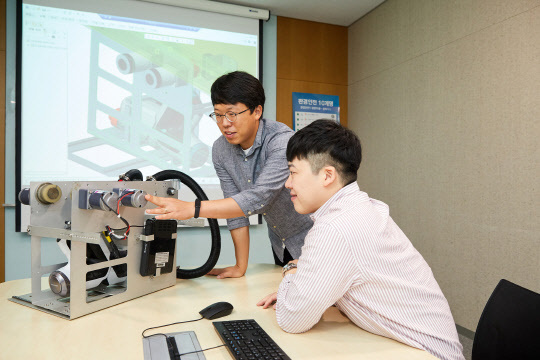 클리닝 로봇을 개발한 삼성디스플레이 중소형기술혁신팀의 박광돈(왼쪽) 프로와 정우현 프로가 로봇 개선 방안에 대해 논의하고 있다. <삼성디스플레이 제공>
