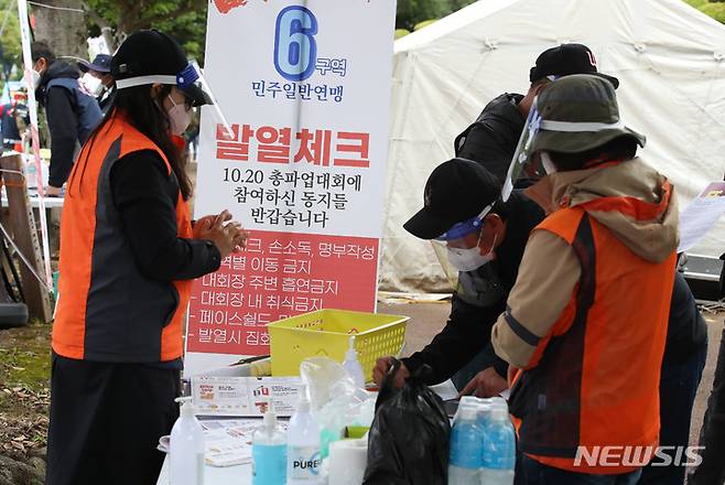 [제주=뉴시스] 우장호 기자 = 전국민주노동조합총연맹의 대규모 총파업 집회가 열린 20일 오후 제주시 연동 제주도청 앞 도로에서 400여명의 조합원들이 참석한 가운데 민주노총 제주본부 총파업 결의대회가 진행되고 있다. 결의대회에 참석한 조합원들이 코로나19 예방을 위한 발열체크를 하고 있다. 2021.10.20. woo1223@newsis.com