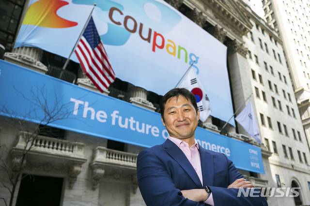 [뉴욕=AP/뉴시스]김범석 쿠팡 이사회 의장이 미국 뉴욕증권거래소(NYSE) 상장 첫날인 11일(현지시간) 쿠팡 배너가 정면을 장식한 뉴욕증권거래소 앞에서 웃으며 포즈를 취하고 있다. 쿠팡은 종목 코드 CPNG로 뉴욕 증시에 입성했다. 2021.3.12.