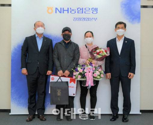 NH농협은행 김평태 외환사업부장(사진 오른쪽)이 지난 20일 고객에게 꽃바구니와 기념 선물을 전달하며 기념사진을 찍고 있다.(사진=NH농협은행)