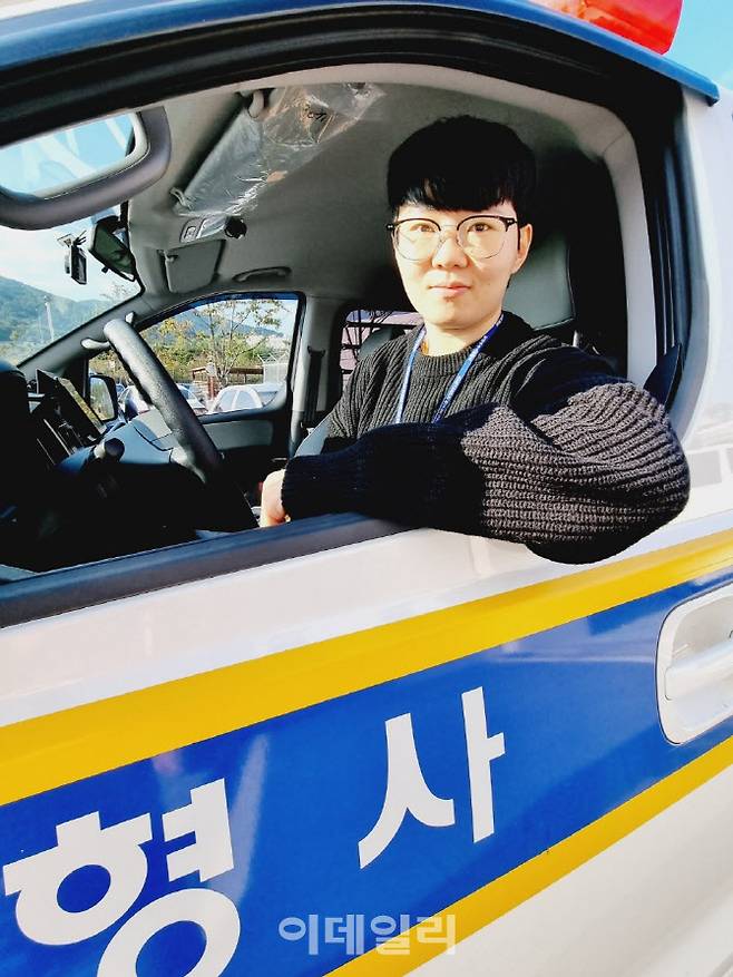 최진선 순경이 형사과 경찰차에 앉아 포즈를 취하고 있다.(사진=정재훈기자)