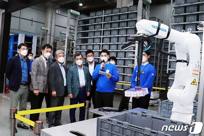 강신호 CJ대한통운 대표이사(왼쪽 네번째)와 김경훈 TES물류기술연구소장(왼쪽 두번째) 등 주요 경영진들이 TES 이노베이션 센터에서 '피스 피킹 시스템' 시연을 보고 있다. (CJ대한통운 제공) © 뉴스1