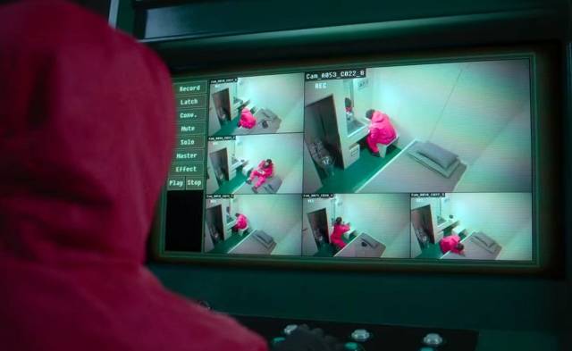 오징어게임 제3화 '우산을 쓴 남자'편에서 상급자 일꾼이 일과를 마치고 개인 숙소에서 휴식을 취하는 일꾼을 CCTV로 실시간 감사하고 있다. 넷플릭스 화면 캡처