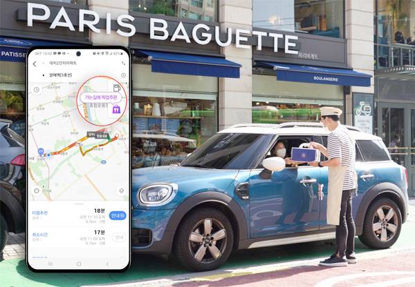 한 운전자가 티맵모빌리티의 운전자 대상 포장주문 서비스 `티맵 픽업`으로 케이크를 주문해 찾아가고 있다.  [사진 제공 = 티맵모빌리티]