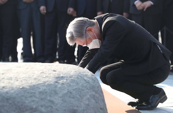 더불어민주당 대선 후보인 이재명 경기도지사가 22일 오후 경남 김해시 진영읍 봉하마을 노무현 전 대통령 묘역을 참배하며 앉아 너럭바위를 만지고 있다. 연합뉴스