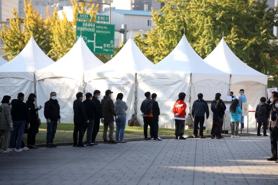 지난 22일 오전 서울 종로구 흥인지문(동대문) 인근에 설치된 선별진료소에서 시민들이 검사를 받기 위해 줄을 서고 있다. (사진=뉴시스)
