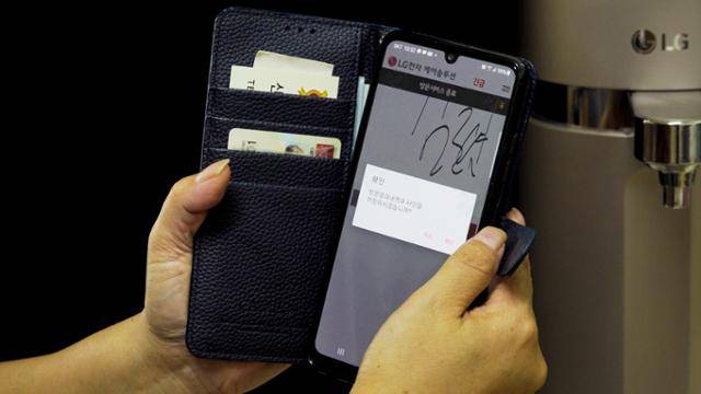 신씨가 고객의 정수기 점검을 마친 후 기기 뒤편에 붙어 있는 QR코드를 스캔해 어플리케이션에 입력하고 있다. 방문 시간과 점검 완료 시간이 기록된다. 한 고객의 집에 최소 15분 이상은 머물러야 한다.