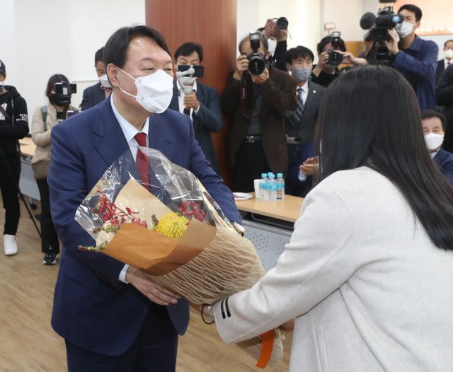 국민의힘 대선 주자 윤석열 전 검찰총장이 23일 오후 울산시당 이전 개소식에 참석해 꽃다발을 받고 있다. 연합뉴스