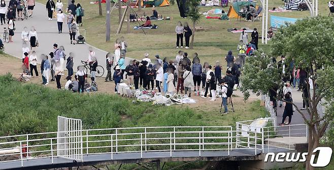 (서울=뉴스1) 김진환 기자 = 23일 오후 서울 서초구 반포한강공원 수상택시 승강장 인근 대학생 손모씨(22) 추모 공간에 시민들의 발길이 이어지고 있다. 2021.5.23/뉴스1