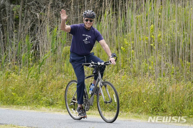 [레호보스비치=AP/뉴시스]조 바이든 미국 대통령이 3일(현지시간) 미 델라웨어주 레호보스 비치에서 부인 질 여사와 함께 자전거를 타며 손을 흔들고 있다. 바이든 대통령은 부인 질 여사의 70번째 생일을 맞아 이곳 별장에 머물고 있다. 2021.06.04.
